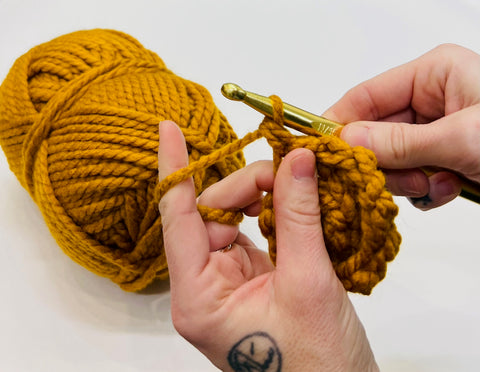 hands crocheting hats
