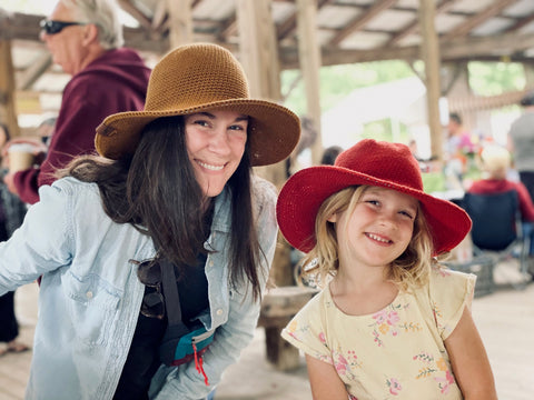 mother and daughter customers at the farmers market wearing matching north ferry sun hats