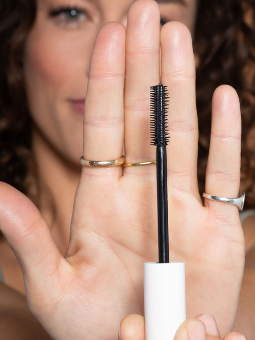 Woman With Raised Hand Holding ILIA Mascara