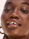 Tahiti Balmy Gloss a burnt-coral tinted lip oil and lip gloss on model