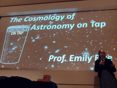 Emily in front of a large screen reading "Cosmology of Astronomy on Tap"