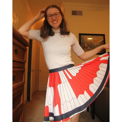 Erin posing in her Mars 2020 parachute skirt, with one hand on her head and the other holding the hem of the skirt out to show off the pattern.