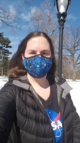 Emily wearing a blue starry mask and a NASA meatball t-shirt