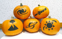 Five pumpkins with simple science-themed designs on them on black, on a white textured background