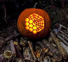 Hald JWST hexangonal segmented mirror, hald spiderweb design carved on a pumpking glowing from the inside, on a dark spooky background