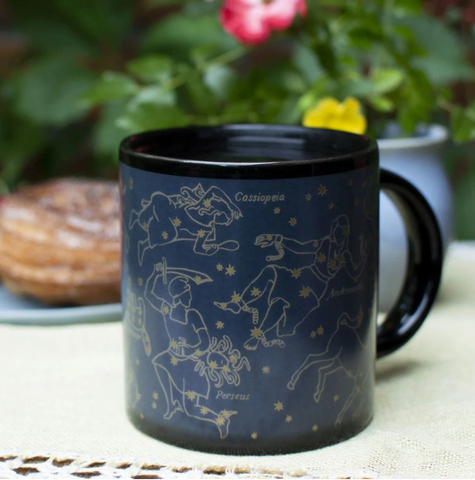 A black mug with gold constellations on it