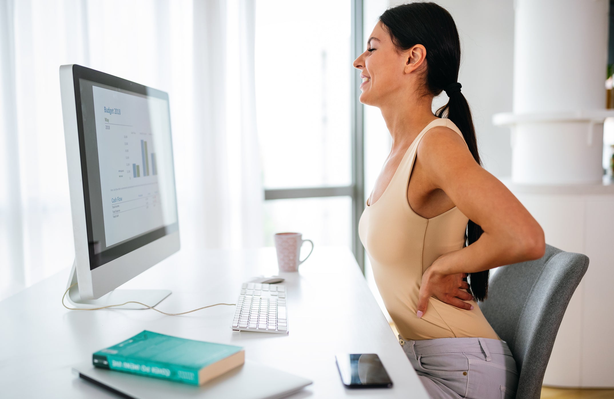 Girl suffering from back pain at work