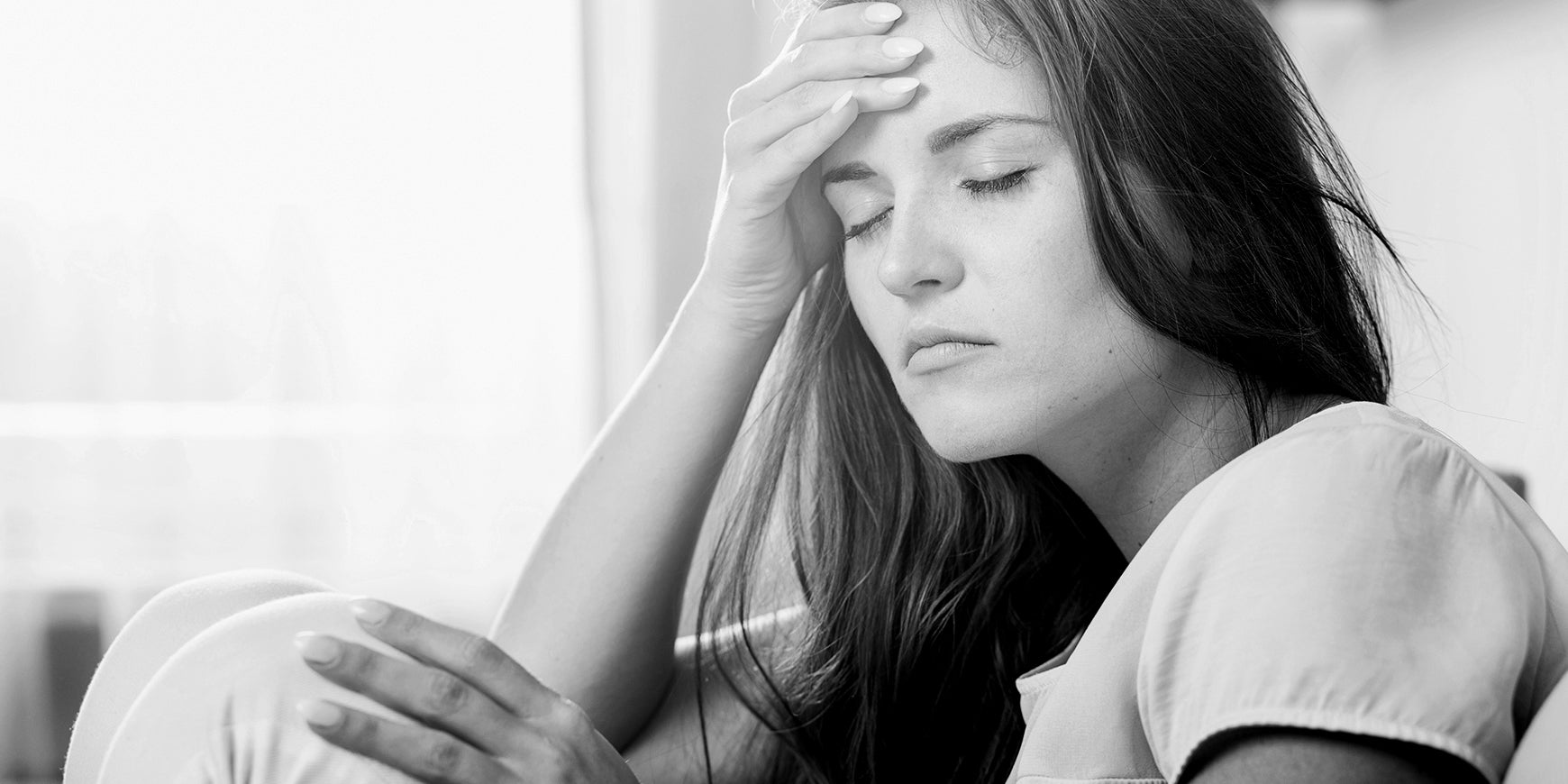 Woman holding head and looking tired