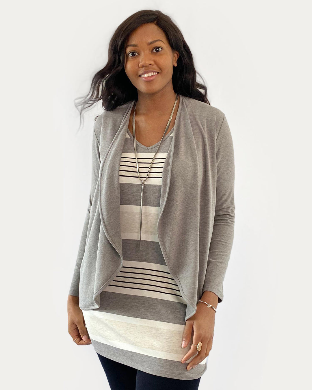 Woman wearing a grey cardigan over a striped top