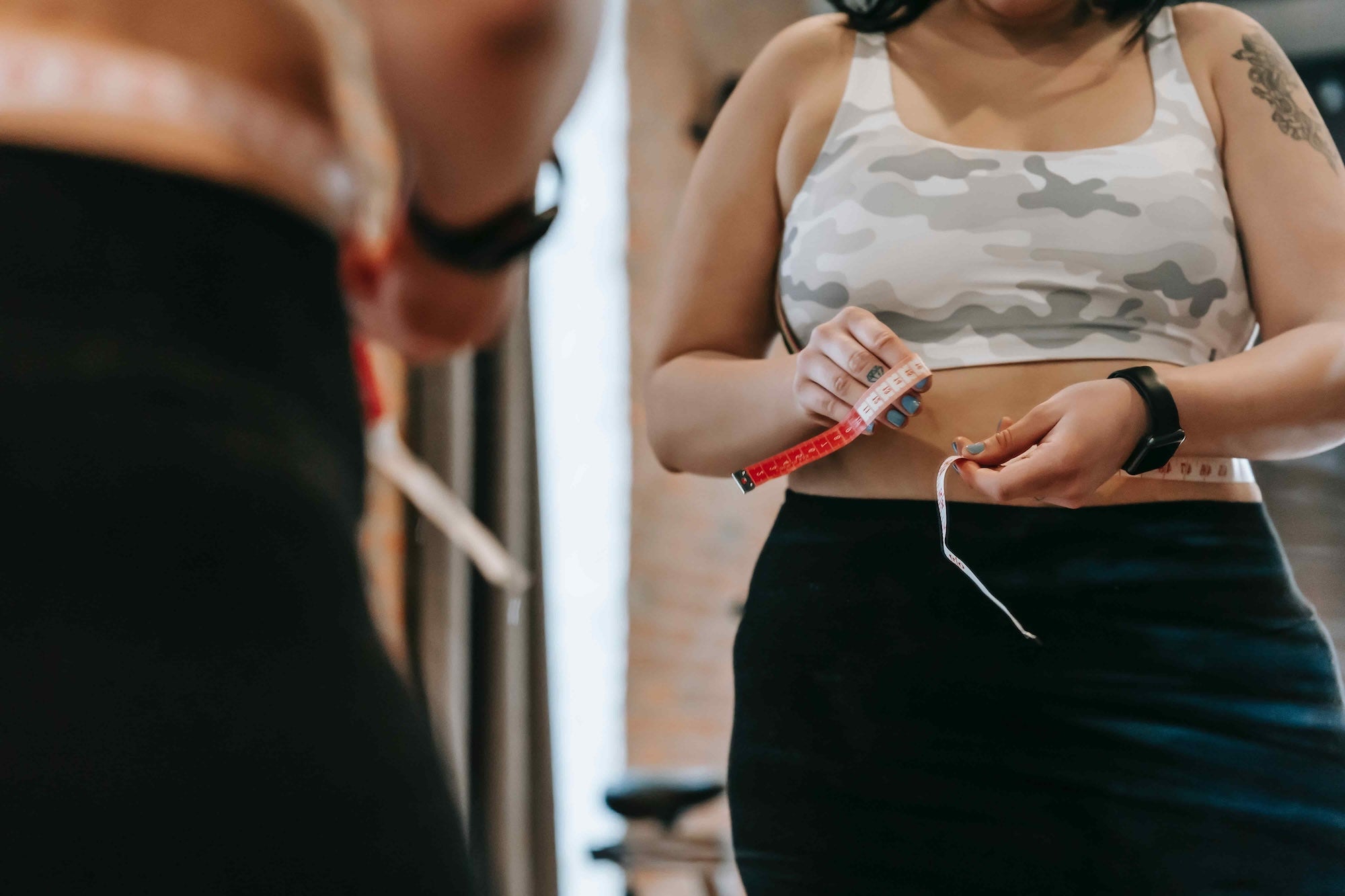 Woman standing in front of a mirror getting measured.