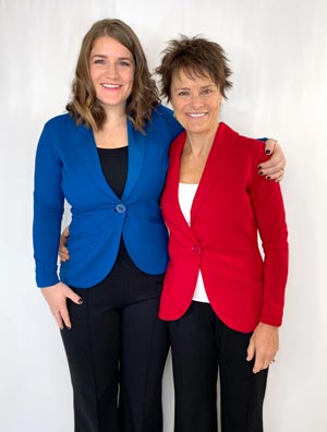 Two women wearing blazers