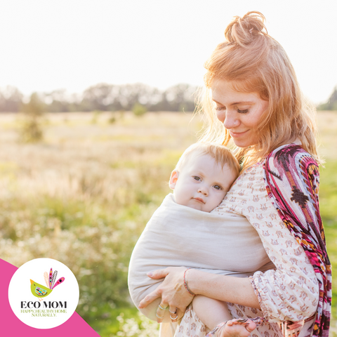 Mother wearing a baby in a wrap carrier outdoors