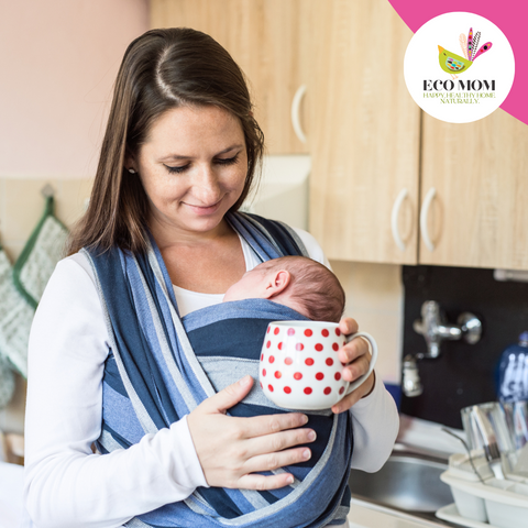 Busy mother wearing baby in stretchy wrap carrier