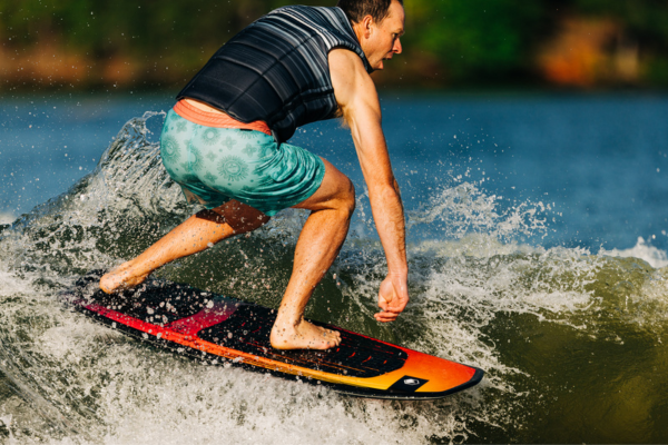 Man riding a Liquid Force Pod wakesurf board
