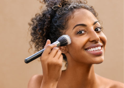 a women applying bronzer with a face brush