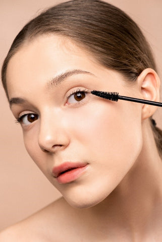 women applying mascara  