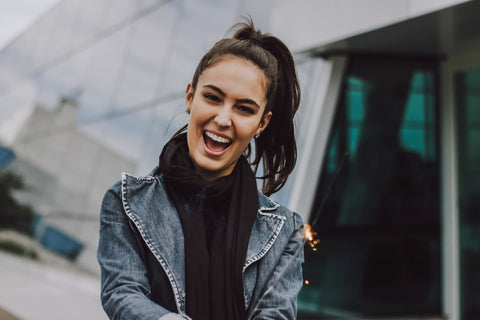 Women with denim jacket and black hair whit teeth smiling 