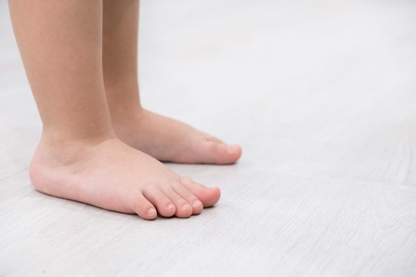 Children bare feet on wooden floor