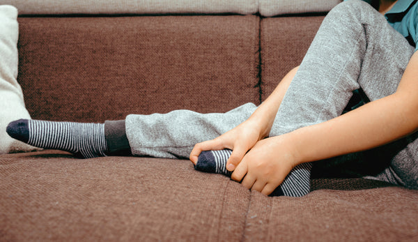 Kleine jongen houdt zijn voet vast