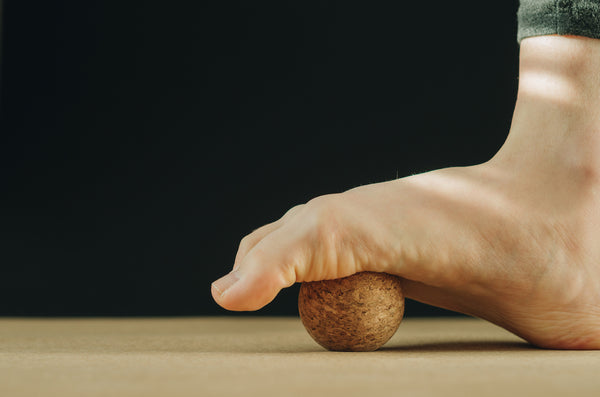 Man foot massage on cork ball