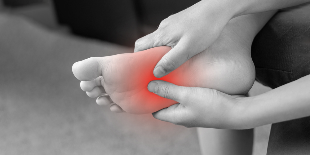 Osoba cierpiąca na ból przedniej części stopy w czerni i bieli