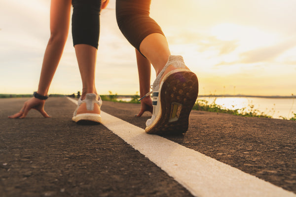 sport runner feet running on sunset