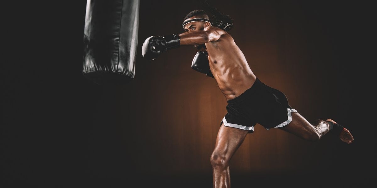 vue latérale de l'entraînement de combattant muay thai avec sac de boxe, concept de sport d'action