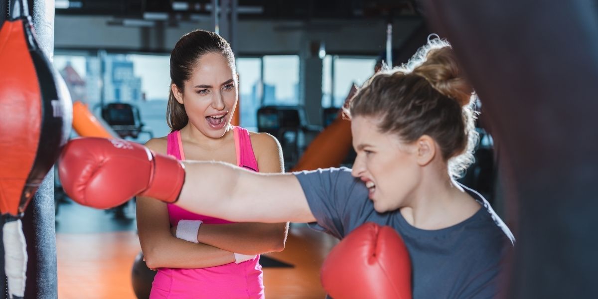 femme en surpoids ayant la formation de boxe tout en criant l'entraîneur