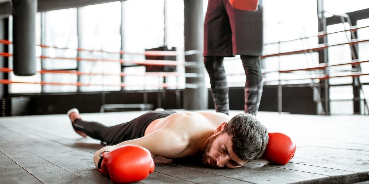 Boxeur tombant sur le sol lors d'une bataille de boxe
