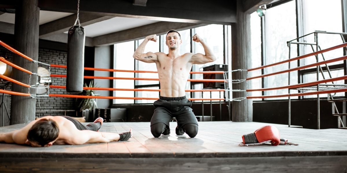 Boxeur vainqueur avec homme battu sur le ring de boxe