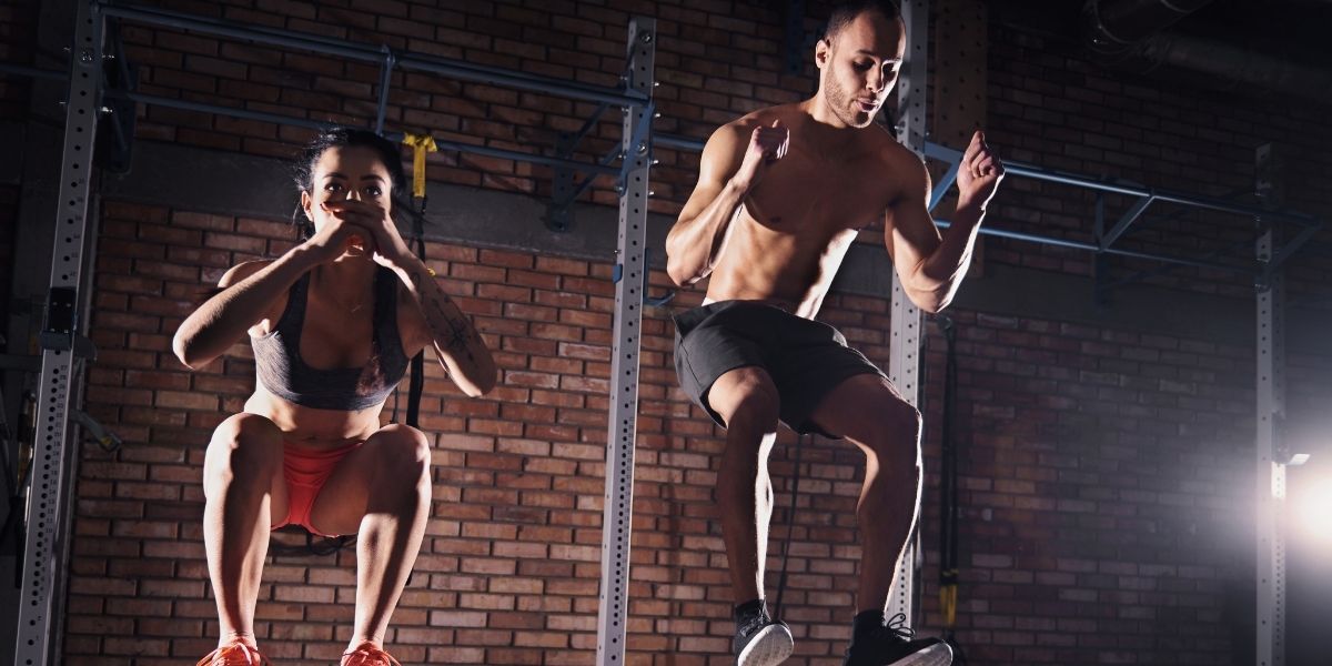 couple qui fait des squats à la salle de boxe