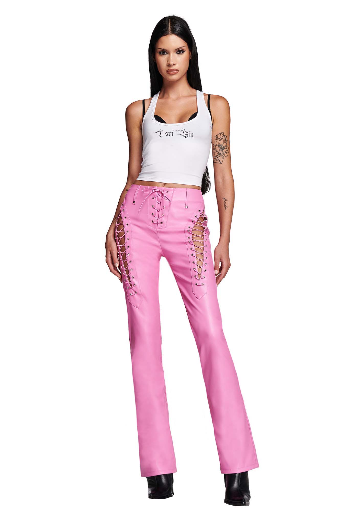 Premium Photo  Sexy woman in pink leather pants is standing under the lilac
