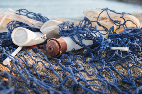 Plastic bottles in fishing net on the ocean shore. 