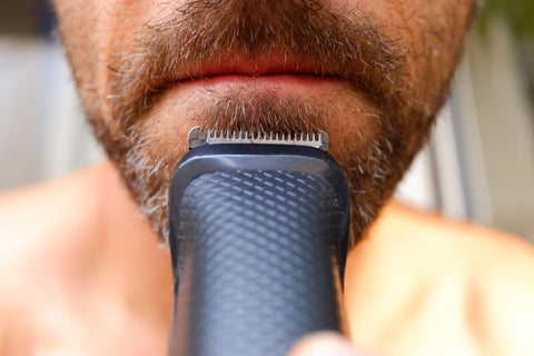 Man trimming his beard at home