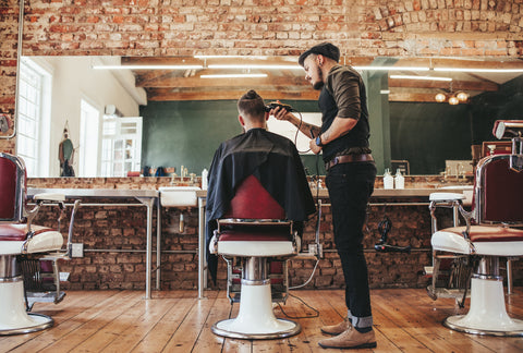 A barber working on his client's hair