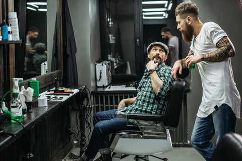 Barber with a client discussing hair tools