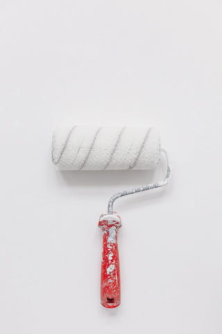 white paint brush with red handle
