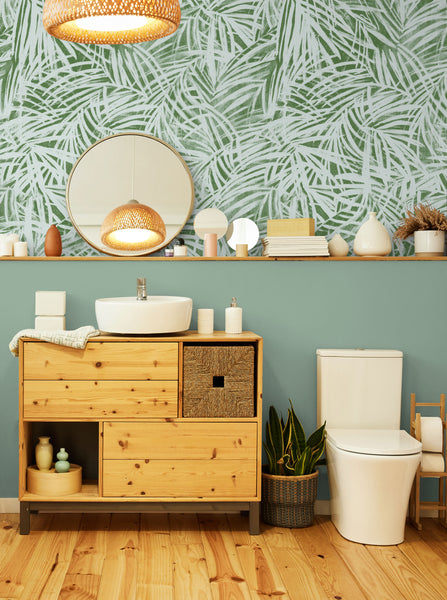Tropical wallpaper installed in a green powder room.