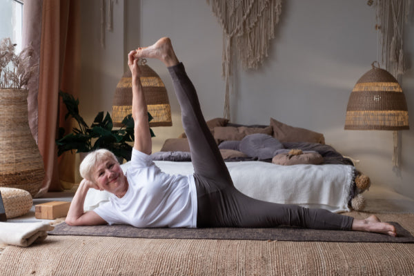 4 exercises for back pain relief senior woman doing lateral leg lift to help with back pain