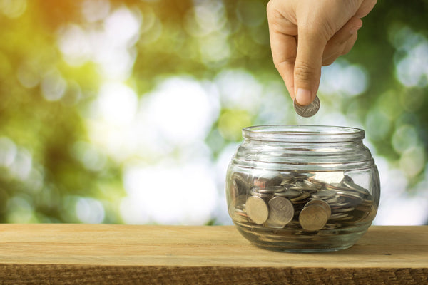 Person putting a coin in a jar full of coins