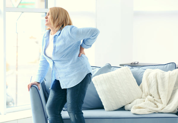 Middle-aged woman grasping her back in discomfort
