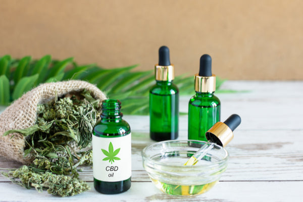alternatives to ibuprofen natural remedies for pain cbd oil in green glass jars with dry flower on wooden table