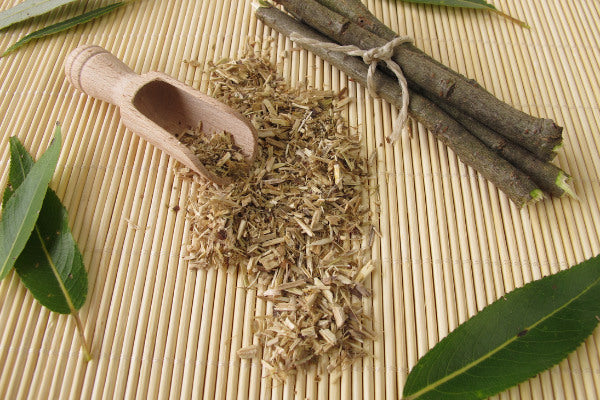 alternatives to ibuprofen natural remedies for pain willow bark sitting on bamboo mat with scoop close up