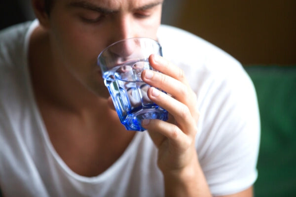 are you drinking enough water dehydration and pain man drinking from glass