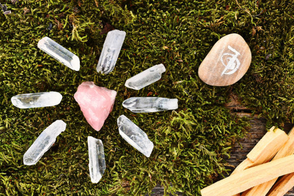 crystal points the benefits how to use them quartz points crystals in a grid with rose quartz on moss close up