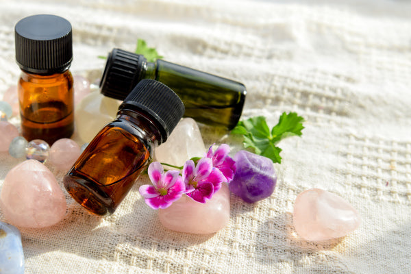 essential oils for cleansing charging crystals amber glass essential oils laying on bed of healing crystals