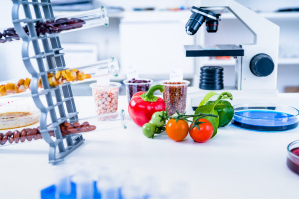 foods that boost your mood yes please foods sitting on lab counter next to a microscope close up