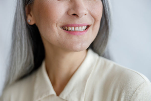 how hyaluronic acid works middle aged woman with healthy skin smiling close up