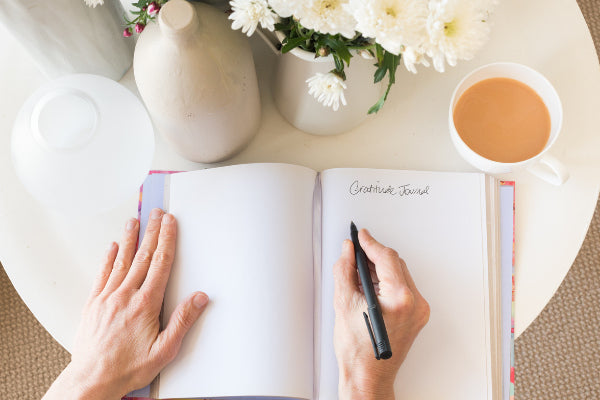 how to have a reset day person writing in gratitude journal to help realign their heart on day of rest
