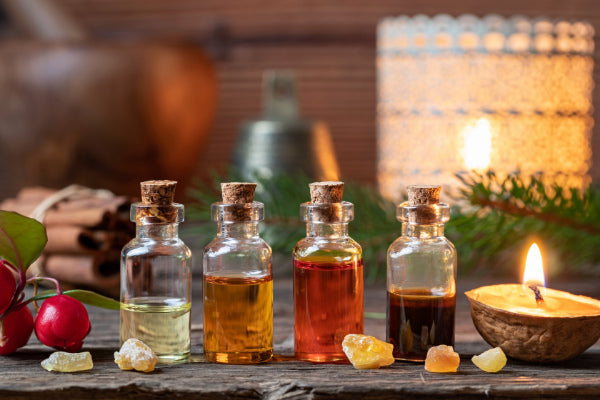 inner warrior for nerve pain essential oils in glass bottles sitting on wooden table with walnut candle close up